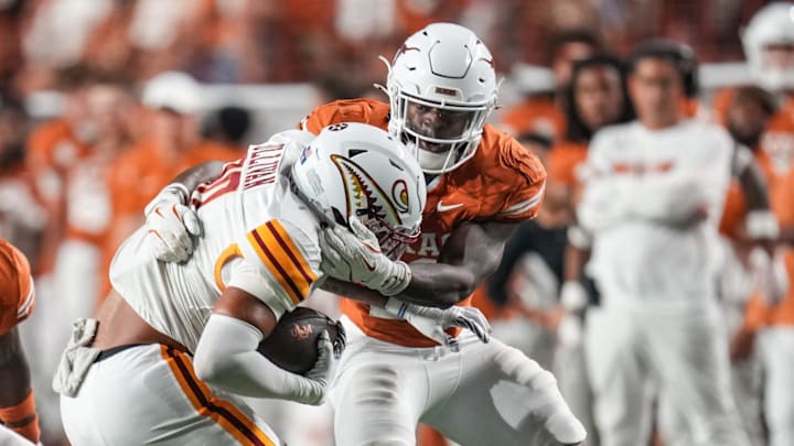 Texas Longhorns defensive back Jordon Johnson-Rubell (23) and Texas Longhorns linebacker Colin Simmons (11) take down Louisiana Monroe Warhawks tight end Nate Sullivan Jr. (80) as the Texas Longhorns take on ULM at Darrell K Royal-Texas Memorial Stadium in Austin Saturday, Sept. 21, 2024.