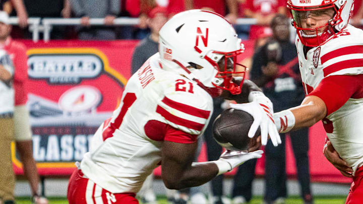 Nebraska Cornhuskers quarterback Dylan Raiola hands the ball off to running back Emmett Johnson against the Cincinnati Bearcats at GEHA Field at Arrowhead Stadium.