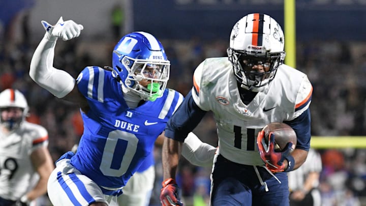 Nov 15, 2025; Durham, North Carolina, USA;  Duke Blue Devils cornerback Chandler Rivers (0) attempts to swat the ball from Virginia Cavaliers wide receiver Trell Harris (11) during the third quarter at Wallace Wade Stadium. Mandatory Credit: Zachary Taft-Imagn Images