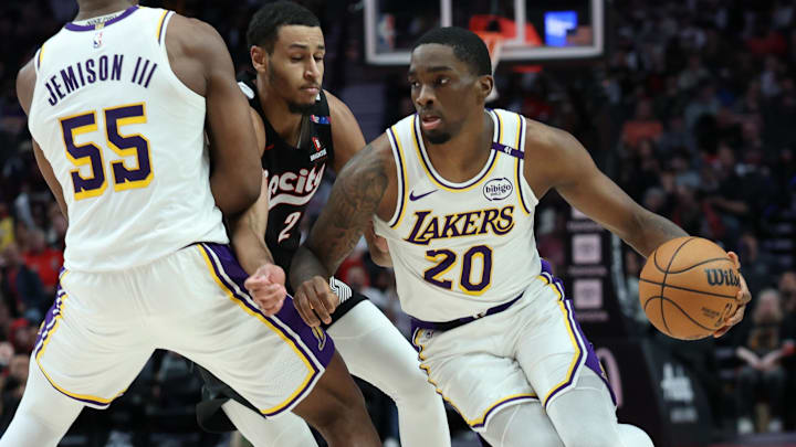 Former Los Angeles Lakers guard Shake Milton (20) dribbles the ball around his teammate, Lakers’ center Trey Jemison III (55), past Portland Trail Blazers forward Kris Murray (24) in the second half at Moda Center.