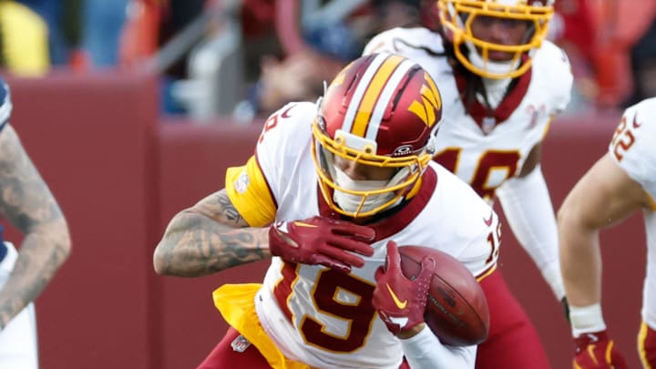 Dallas Cowboys cornerback C.J. Goodwin tackles Washington Commanders wide receiver Chris Moore.