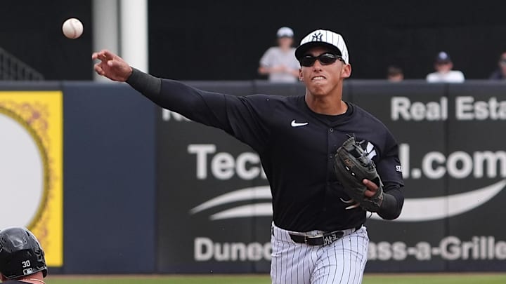 Mar 10, 2025; Tampa, Florida, USA; New York Yankees shortstop George Lombard Jr. (96) throws to first to make the double play as Detroit Tigers outfielder Kerry Carpenter (30) slides into second during the first inning at George M. Steinbrenner Field.