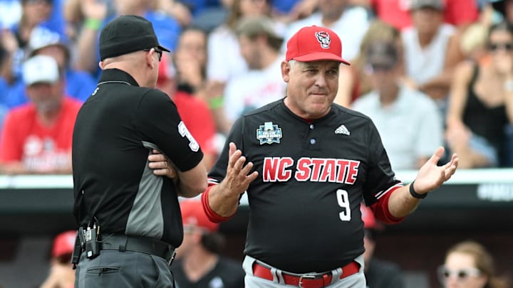 Jun 15, 2024; Omaha, NE, USA;  NC State Wolfpack head coach Elliott Avent discusses a balk call with an umpire in the game against the Kentucky Wildcats during the eighth inning at Charles Schwab Field Omaha. Mandatory Credit: Steven Branscombe-Imagn Images