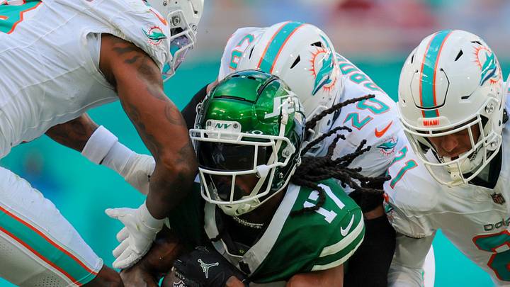 New York Jets wide receiver Davante Adams (17) is stopped by Miami Dolphins linebacker Jordyn Brooks (20), safety Jordan Poyer (21), and safety Jevon Holland (8) afte running with the football during the second quarter at Hard Rock Stadium. New York Jets wide receiver Davante Adams (17) is stopped by Miami Dolphins linebacker Jordyn Brooks (20), safety Jordan Poyer (21), and safety Jevon Holland (8) afte running with the football during the second quarter at Hard Rock Stadium.
