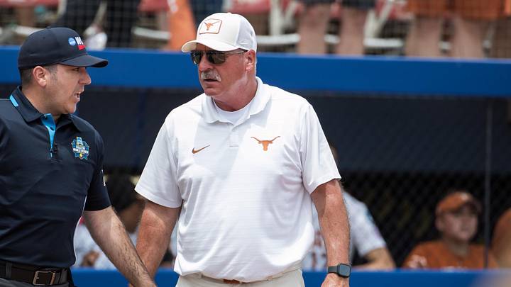 Texas Longhorns head coach Mike White talks to the home plate umpire in the sixth inning against the Tennessee Lady Volunteers.
