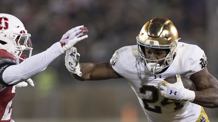 Nov 29, 2025; Stanford, California, USA;  Notre Dame Fighting Irish running back Jadarian Price (24) runs with the football against Stanford Cardinal safety Darrius Davis (29) during the first quarter at Stanford Stadium. Mandatory Credit: Stan Szeto-Imagn Images