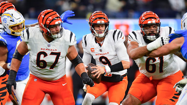 Nov 17, 2024; Inglewood, California, USA; Cincinnati Bengals quarterback Joe Burrow (9) moves out to pass as guard Cody Ford (61) and guard Cordell Volson (67) provide coverage against Los Angeles Chargers linebacker Joey Bosa (97) during the first half at SoFi Stadium. Mandatory Credit: Gary A. Vasquez-Imagn Images