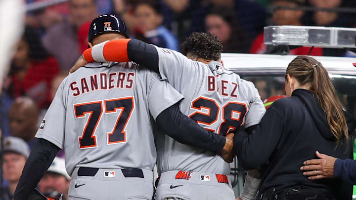Detroit Tigers center fielder Javier Baez (28) is assisted by first base coach Anthony Sanders (77) after an injury. 