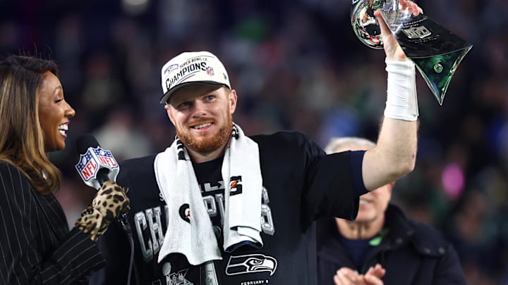 Feb 8, 2026; Santa Clara, CA, USA; Seattle Seahawks quarterback Sam Darnold (14) celebrates with the Vince Lombardi trophy on the podium after defeating the New England Patriots in Super Bowl LX at Levi's Stadium. Mandatory Credit: Mark J. Rebilas-Imagn Images