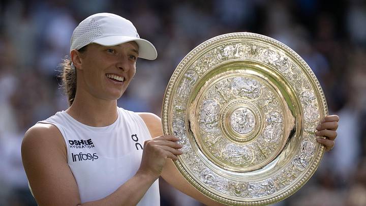 Iga Swiatek poses with the trophy after winning Wimbledon 2025
