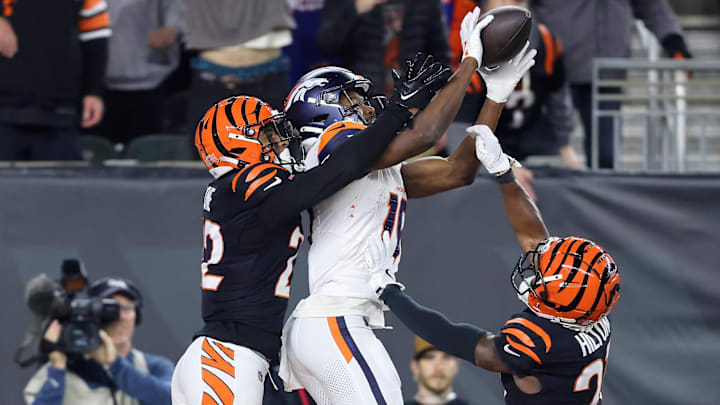 Dec 28, 2024; Cincinnati, Ohio, USA; Denver Broncos wide receiver Marvin Mims Jr. (19) catches a touchdown pass against Cincinnati Bengals cornerback Mike Hilton (21) and safety Geno Stone (22) during the fourth quarter at Paycor Stadium. 