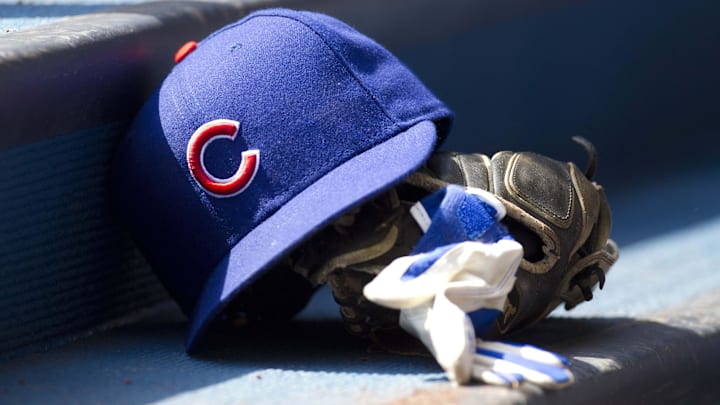 Chicago Cubs hat and glove in the dugout