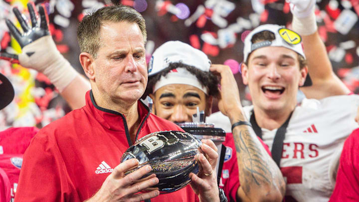 Indiana coach Curt Cignetti looks at the Big Ten championship trophy at Lucas Oil Stadium.