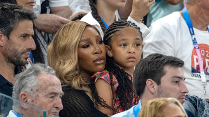 Serena Williams holds daughter Olympia while watching the women's gymnastics team final at the 2024 Paris Olympics.