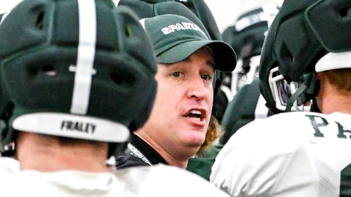 Michigan State's head coach Pat Fitzgerald, center, huddles up with the team during spring football practice on Tuesday, April 14, 2026, in East Lansing.
