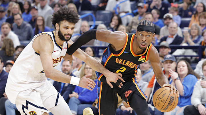 Mar 9, 2025; Oklahoma City, Oklahoma, USA; Oklahoma City Thunder guard Shai Gilgeous-Alexander (2) drives around Denver Nuggets guard Jamal Murray (27) during the second half at Paycom Center. Mandatory Credit: Alonzo Adams-Imagn Images Mar 9, 2025; Oklahoma City, Oklahoma, USA; Oklahoma City Thunder guard Shai Gilgeous-Alexander (2) drives around Denver Nuggets guard Jamal Murray (27) during the second half at Paycom Center. Mandatory Credit: Alonzo Adams-Imagn Images