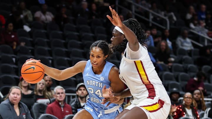 Oct 30, 2025; Atlanta, GA, USA; North Carolina Tar Heels guard Indya Nivar (24) dribbles the ball toward the basket against South Carolina Gamecocks center Madina Okot (11) during the first quarter at State Farm Arena. Mandatory Credit: Jordan Godfree-Imagn Images