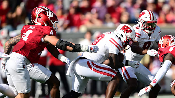 Nov 15, 2025; Bloomington, Indiana, USA;  Wisconsin Badgers running back Gideon Ituka (10) runs the ball past Indiana Hoosiers linebacker Aiden Fisher (4) during the second quarter at Memorial Stadium.