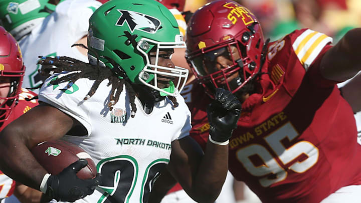 Iowa State Cyclones defensive line Domonique Orange (95) and inebacker Jack Sadowsky (33) attempt to tackle as North Dakota Fighting Hawks running back Isaiah Smith (29) runs for first down during the fourth quarter in the season opening game at Jack Trice Stadium on Aug. 31, 2024,  in Ames, Iowa