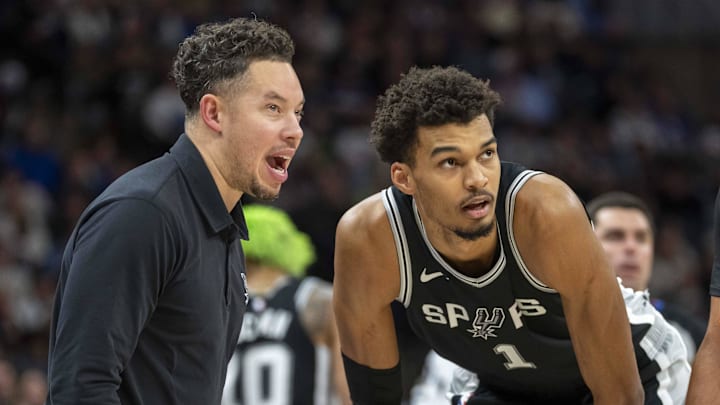 San Antonio Spurs interim head coach Mitch Johnson talks with center Victor Wembanyama during a free throw against the Minnesota Timberwolves in the second half at Target Center.