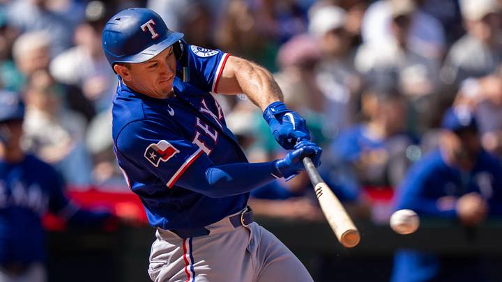 Texas Rangers left fielder Wyatt Langford hits a baseball with his bat.
