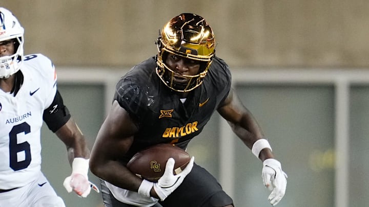 Baylor Bears tight end Michael Trigg runs with the ball after the catch ahead of Auburn Tigers linebacker Demarcus Riddick