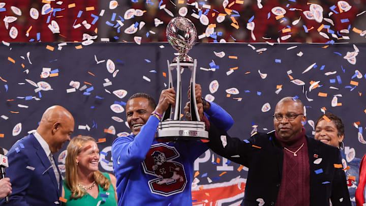 Dec 13, 2025; Atlanta, GA, USA; South Carolina State Bulldogs head coach Chennis Berry holds the trophy after a victory over the Prairie View A&M Panthers in quadruple overtime of the Celebration Bowl at Mercedes-Benz Stadium. Mandatory Credit: Brett Davis-Imagn Images
Dec 13, 2025; Atlanta, GA, USA; South Carolina State Bulldogs head coach Chennis Berry holds the trophy after a victory over the Prairie View A&M Panthers in quadruple overtime of the Celebration Bowl at Mercedes-Benz Stadium. Mandatory Credit: Brett Davis-Imagn Images