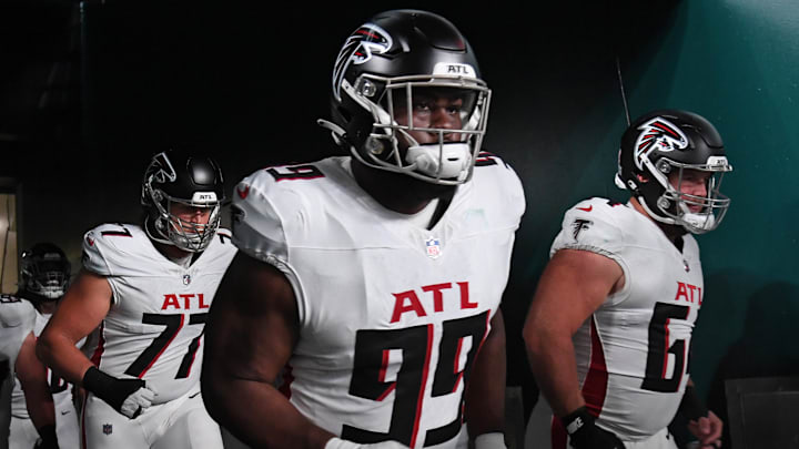 Sep 16, 2024; Philadelphia, Pennsylvania, USA; Atlanta Falcons defensive tackle Eddie Goldman (99) and guard Ryan Neuzil (64) run onto the field against the Philadelphia Eagles at Lincoln Financial Field. Mandatory Credit: Eric Hartline-Imagn Images