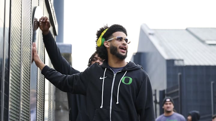 Nov 14, 2025; Eugene, Oregon, USA; Oregon Ducks quarterback Dante Moore (5) swipes his hand over the letter “O” during the “March to Victory” team walk before a game against the Minnesota Golden Gophers at Autzen Stadium. 