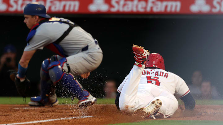 Angels third baseman Yoan Moncada (5) scores a run on a sacrifice fly ahead of a tag from Los Angeles Dodgers catcher Will Smith (16)  during the second inning at Angel Stadium on Aug. 13.