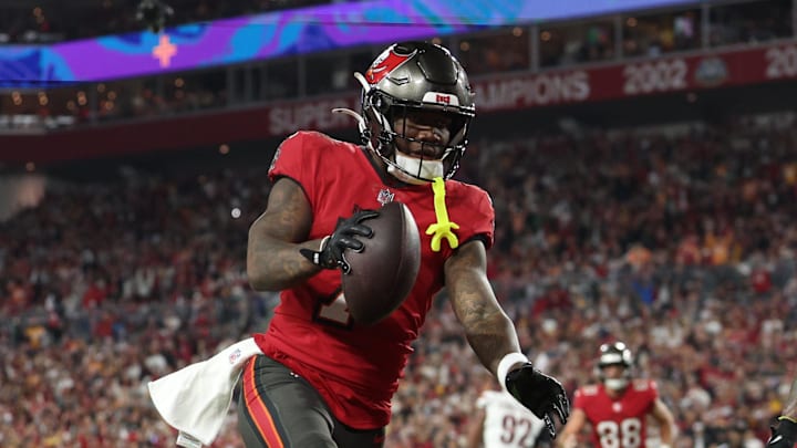 Jan 12, 2025; Tampa, Florida, USA; Tampa Bay Buccaneers running back Bucky Irving (7) makes a touchdown catch against Washington Commanders linebacker Frankie Luvu (4) during the third quarter of a NFC wild card playoff at Raymond James Stadium. Mandatory Credit: Nathan Ray Seebeck-Imagn Images