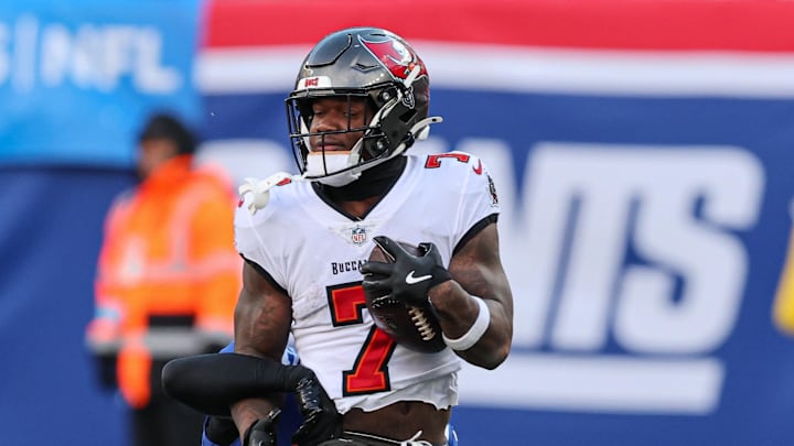 Nov 24, 2024; East Rutherford, New Jersey, USA; Tampa Bay Buccaneers running back Bucky Irving (7) fights for yards as New York Giants cornerback Dru Phillips (22) tackles during the first half at MetLife Stadium. Mandatory Credit: Vincent Carchietta-Imagn Images