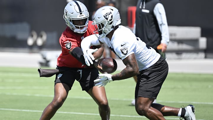 Jun 10, 2025; Henderson, NV, USA; Las Vegas Raiders quarterback Geno Smith (7) hands the ball to running back Raheem Mostert (31) during Las Vegas Raiders Minicamp at Intermountain Health Performance Center. Mandatory Credit: Candice Ward-Imagn Images Jun 10, 2025; Henderson, NV, USA; Las Vegas Raiders quarterback Geno Smith (7) hands the ball to running back Raheem Mostert (31) during Las Vegas Raiders Minicamp at Intermountain Health Performance Center. Mandatory Credit: Candice Ward-Imagn Images