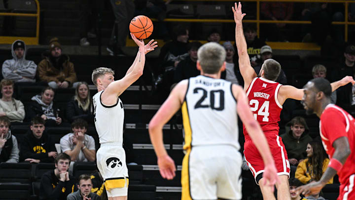  Iowa guard Josh Dix shoots the ball as Nebraska guard Rollie Worster defends.