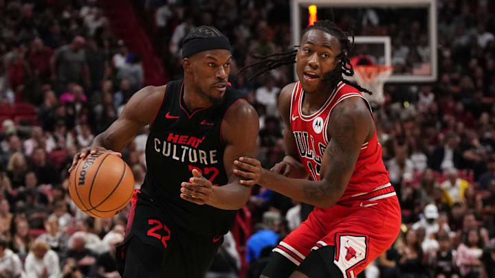 Dec 16, 2023; Miami, Florida, USA; Miami Heat forward Jimmy Butler (22) drives the ball around Chicago Bulls guard Ayo Dosunmu (12) during the second half at Kaseya Center. Mandatory Credit: Jasen Vinlove-Imagn Images