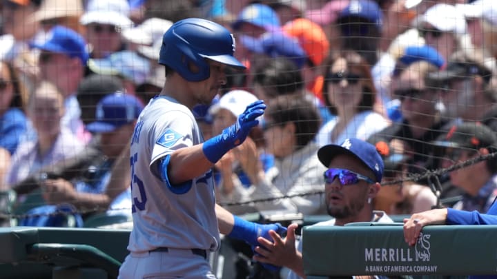 Jul 12, 2025; San Francisco, California, USA; Los Angeles Dodgers third baseman Tommy Edman (left) is congratulated by teammates after hitting an RBI groundout against the San Francisco Giants during the second inning at Oracle Park. Mandatory Credit: Darren Yamashita-Imagn Images
