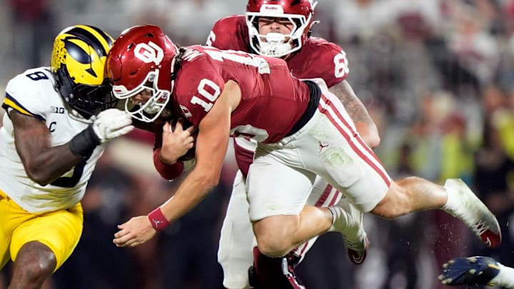 Oklahoma quarterback John Mateer (10) is hit by Michigan's Derrick Moore Oklahoma quarterback John Mateer (10) is hit by Michigan's Derrick Moore