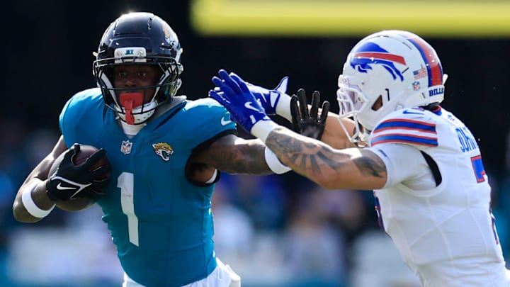Jacksonville Jaguars running back Travis Etienne Jr. (1) rushes for yards against Buffalo Bills cornerback Taron Johnson (7) during the second quarter of an NFL football AFC Wild Card playoff matchup, Sunday, Jan. 11, 2026, in Jacksonville, Fla. [Corey Perrine/Florida Times-Union]