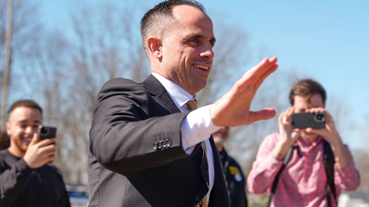 Iowa's new head men's basketball coach Ben McCollum waves at the assembled crowd while walking into his introductory press conference Tuesday, March 25, 2025 at Carver-Hawkeye Arena in Iowa City, Iowa.