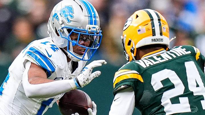 Detroit Lions receiver Amon-Ra St. Brown (14) makes a catch against Green Bay Packers cornerback Carrington Valentine.