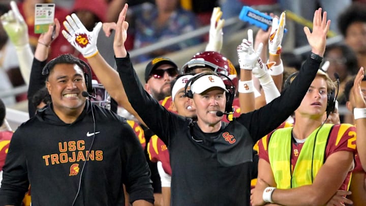Oct 11, 2025; Los Angeles, California, USA;  USC Trojans head coach Lincoln Riley (wearing white visor) celebrates along with defensive end coach Shaun Nua after kicker Ryon Sayeri (48) hit a 54-yard field goal in the second half against the Michigan Wolverines at United Airlines Field at the Los Angeles Memorial Coliseum.