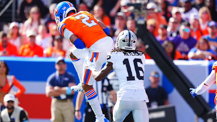 Oct 6, 2024; Denver, Colorado, USA; Denver Broncos cornerback Pat Surtain II (2) pulls in a interception intended for Las Vegas Raiders wide receiver Jakobi Meyers (16) in the second quarter at Empower Field at Mile High. Mandatory Credit: Ron Chenoy-Imagn Images