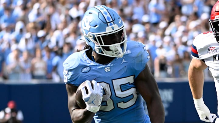 Sep 13, 2025; Chapel Hill, North Carolina, USA; North Carolina Tar Heels running back Demon June (35) with the ball as Richmond Spiders defensive lineman Camden Byrd (6) defends in the second quarter at Kenan Stadium. Mandatory Credit: Bob Donnan-Imagn Images