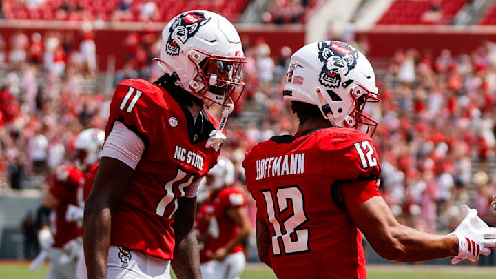 Sep 6, 2025; Raleigh, North Carolina, USA; North Carolina State Wolfpack running back Hollywood Smothers (3),  wide receiver Teddy Hoffmann (12) , and quarterback CJ Bailey (11) celebrate a touchdown during the second half of the game against Virginia Cavaliers at Carter-Finley Stadium. Mandatory Credit: Jaylynn Nash-Imagn Images