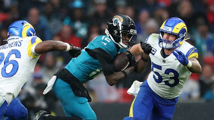 [US, Mexico & Canada customers only] Oct 19, 2025; London, United Kingdom; Jacksonville Jaguars wide receiver Travis Hunter (12) runs with the ball against Los Angeles Rams safety Kamren Kinchens (26) and linebacker Nate Landman (53) during the second half during a NFL International Series game at Wembley Stadium. Mandatory Credit: Andrew Boyers-Reuters via Imagn Images