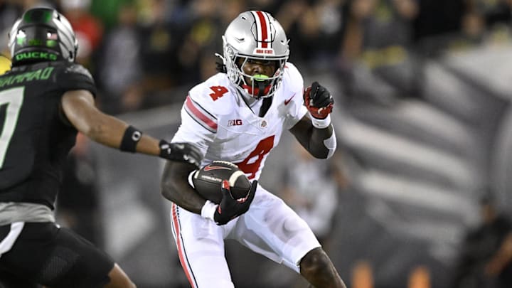 Oct 12, 2024; Eugene, Oregon, USA; Ohio State Buckeyes wide receiver Jeremiah Smith (4) picks up a first down during the second half against Oregon Ducks defensive back Jabbar Muhammad (7) at Autzen Stadium. Mandatory Credit: Troy Wayrynen-Imagn Images