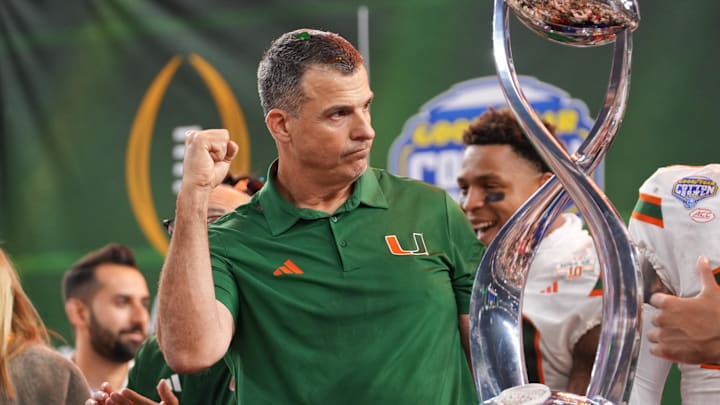 Dec 31, 2025; Arlington, TX, USA; Miami Hurricanes head coach Mario Cristobal lifts the Cotton Bowl trophy after the game against the Ohio State Buckeyes during the 2025 Cotton Bowl and quarterfinal game of the College Football Playoff at AT&T Stadium. Mandatory Credit: Raymond Carlin III-Imagn Images