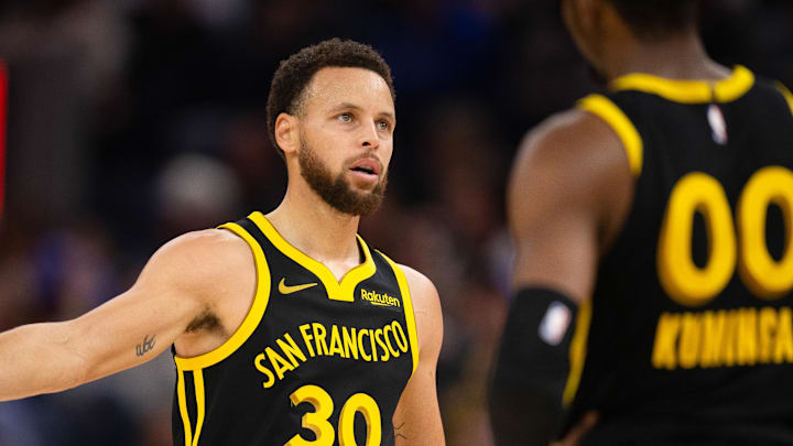 Jan 5, 2024; San Francisco, California, USA; Golden State Warriors guard Stephen Curry (30) gets a handshake from teammate Jonathan Kuminga (00) during the second quarter at Chase Center. Mandatory Credit: D. Ross Cameron-Imagn Images