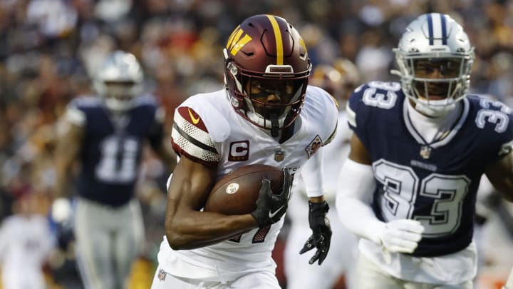Jan 8, 2023; Landover, Maryland, USA; Washington Commanders wide receiver Terry McLaurin (17) runs with the ball for a touchdown as Dallas Cowboys linebacker Damone Clark (33) chases during the first quarter at FedExField. Mandatory Credit: Geoff Burke-USA TODAY Sports