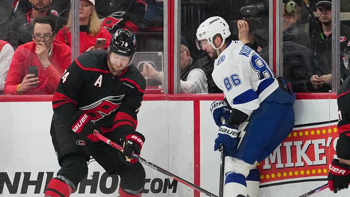 Feb 26, 2026; Raleigh, North Carolina, USA; Carolina Hurricanes defenseman Jaccob Slavin (74) battles for the puck against Tampa Bay Lightning center Jake Guentzel (59) and right wing Nikita Kucherov (86) during the third period at Lenovo Center. Mandatory Credit: James Guillory-Imagn Images